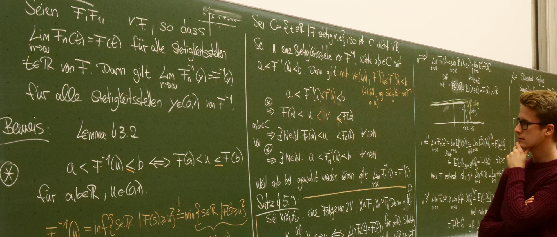 Ein Student steht in nachdenklicher Pose vor einer Tafel voller mathematischer Formel und Beweise.