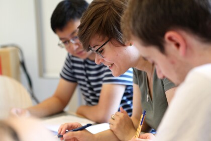 Drei Studierende sitzen nebeneinander und lernen.