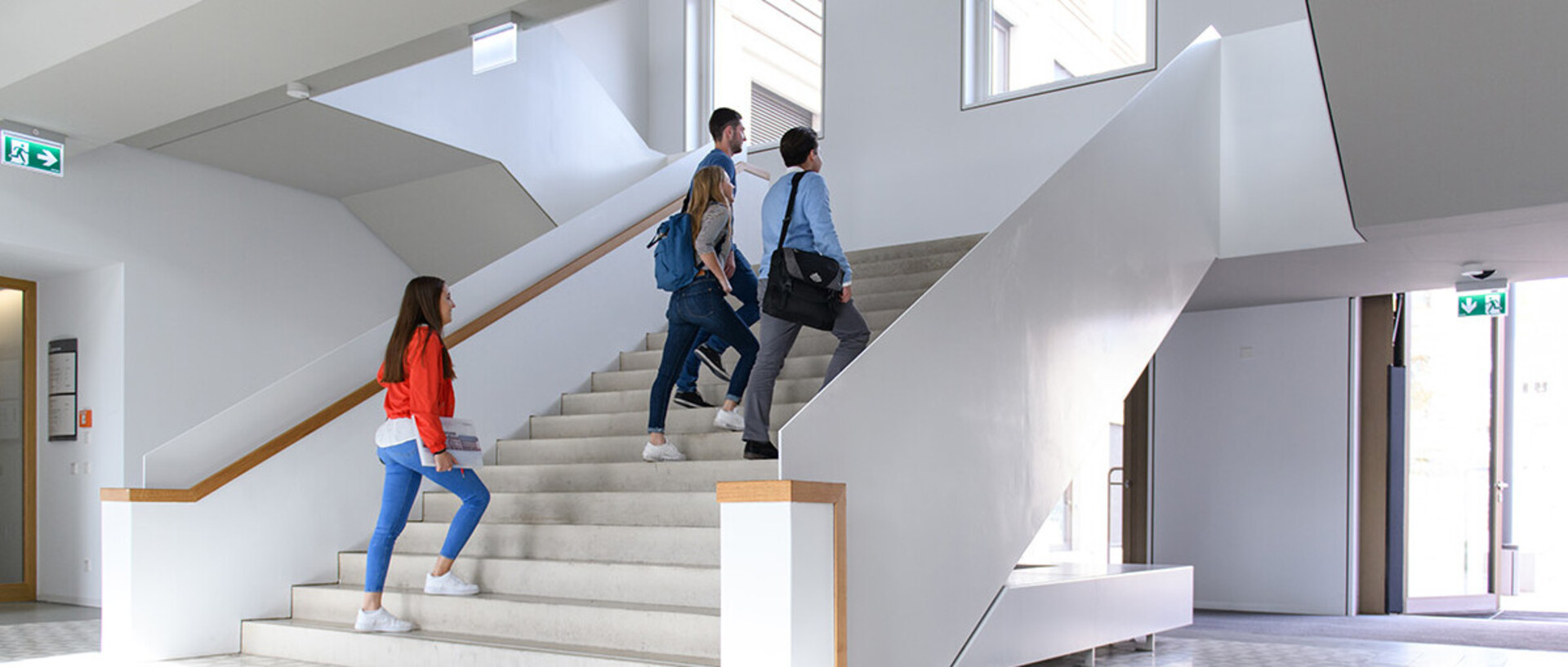vier Studenten, die die Treppen im B6 Gebäude hinaufgehen