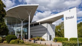 Modernes Gebäude der Universität ENSAI mit Glasfassade und markantem Vordach bei teils bewölktem Himmel.